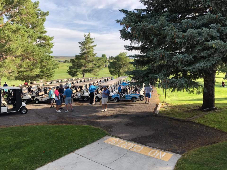 View of golf carts and golfers on golf course